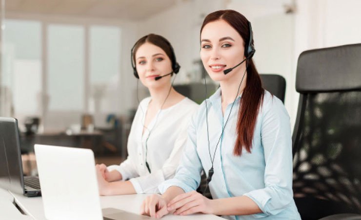 Two girls wearing headphones, smiling while on a phone call